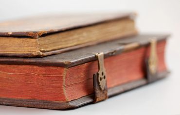 Two old books with leather covers and clasps.