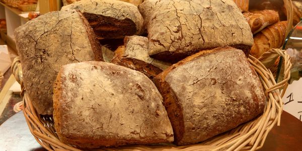 Basket filled with rustic, crusty artisan bread loaves.