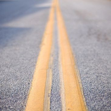 Close-up of worn double yellow lines on an asphalt road.