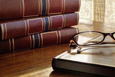 Eyeglasses sitting near a pile of old books