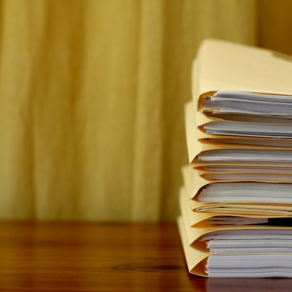 Stack of file folders on wooden surface.