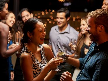 People laughing and toasting at a party.