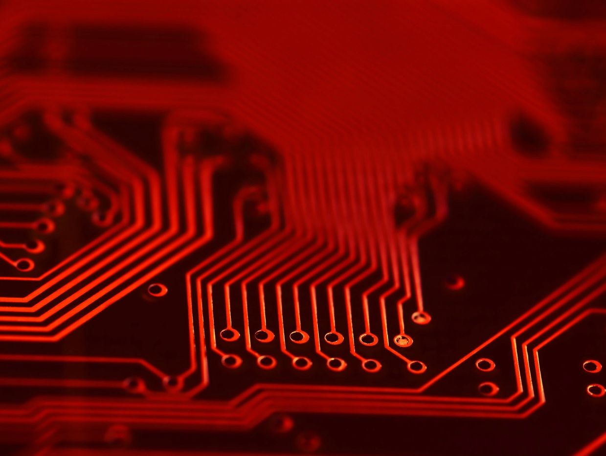 Red-lit circuit board close-up.