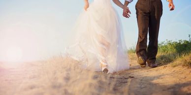 Bride and groom walking on the beach.