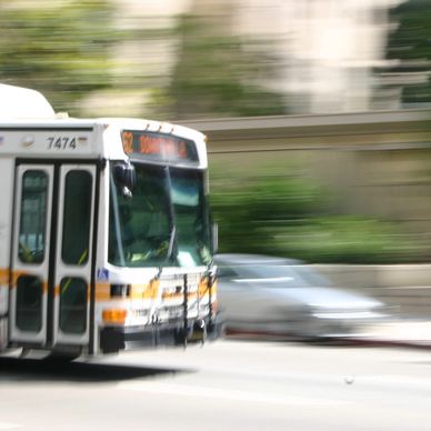 A motion-blurred city bus speeding on a street.