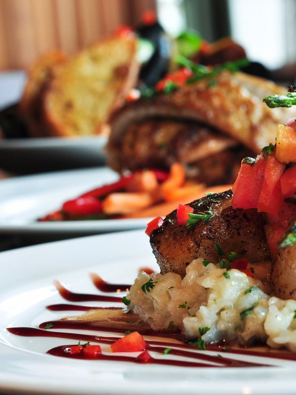 Close-up of a gourmet dish with grilled meat and creamy risotto.