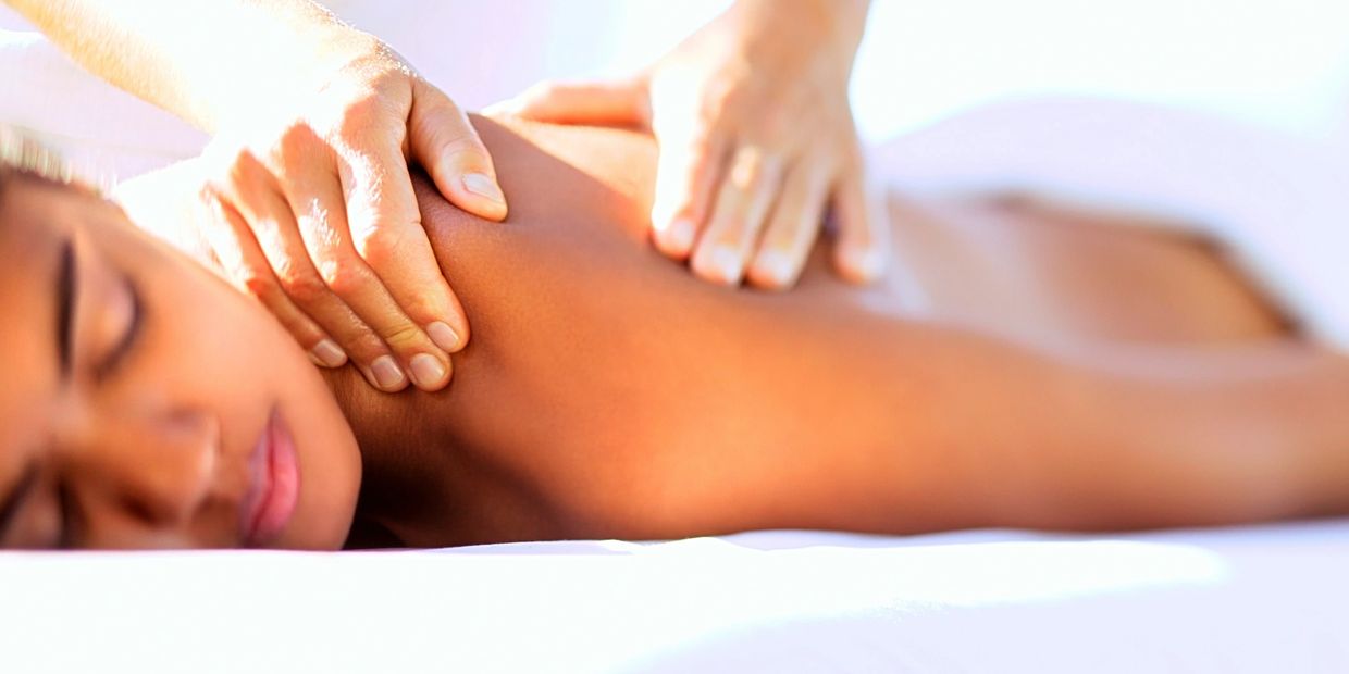 A person on a massage table receiving massage therapy