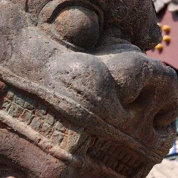 Close-up of an ancient stone sculpture with detailed facial features.
