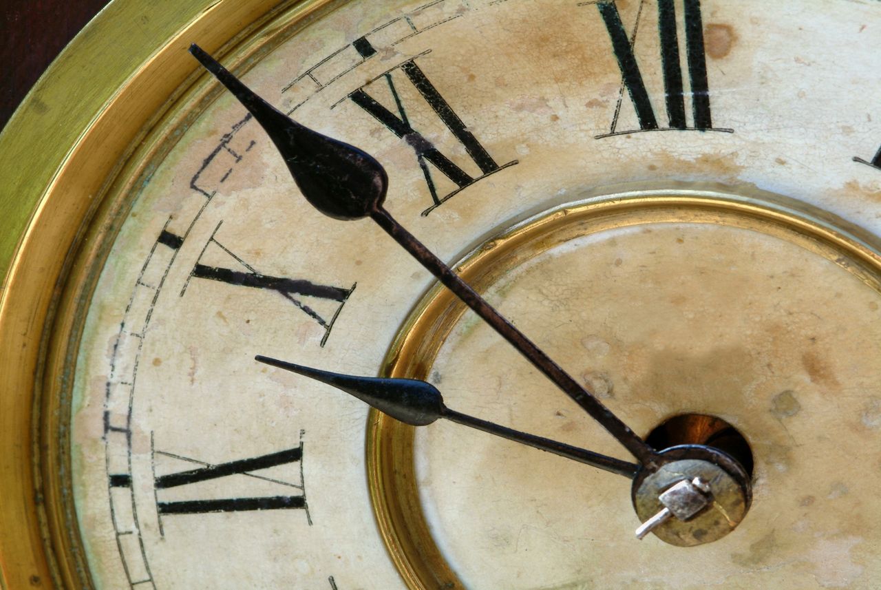 A clock with roman numerals approaches ten o'clock.