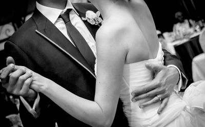Black and white photo of a couple dancing at their wedding.