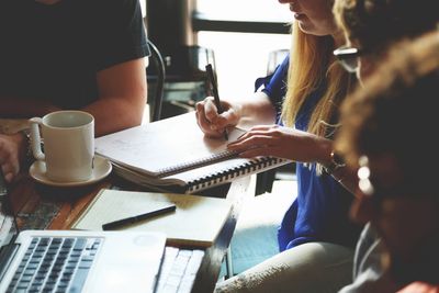 group of people around a notepad and writing