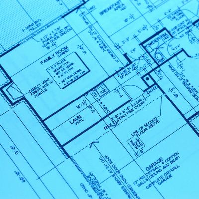 Close-up of a detailed architectural blueprint showing room layouts and measurements.