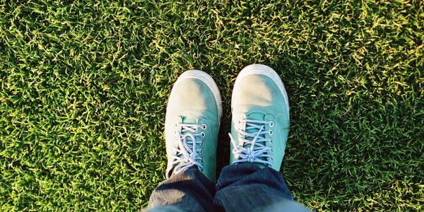 Person in pants and shoes, standing on grass