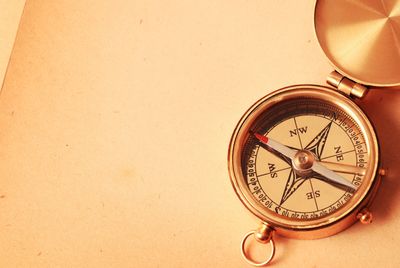 Shiny copper colored compass sitting on a desk.