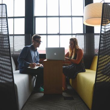 Photo of two people looking at a laptop computer