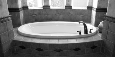 Luxurious tiled soaking tub with custom tile layout.