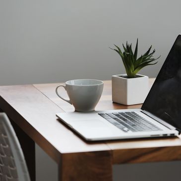 laptop and coffee cup on desk in calm environment