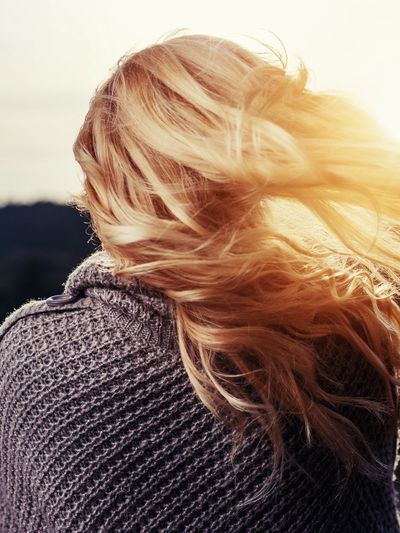 Woman standing in the sunlight feeling sad