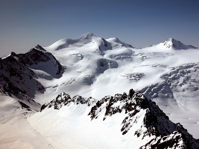 Snow-covered mountain peaks under a clear blue sky.