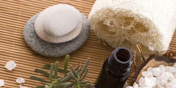 Spa essentials including stones, bottle, salt, and loofah.