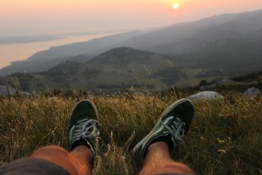 Pessoa descansando na montanha ao pôr do sol.