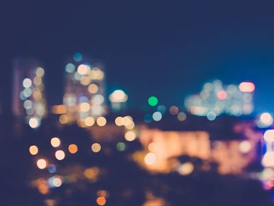 Blurred cityscape at night with colorful bokeh lights.