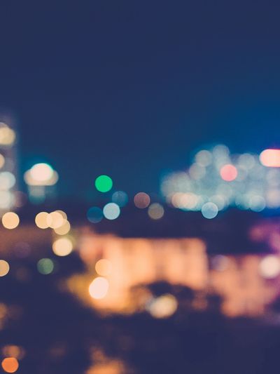Blurred cityscape with colorful bokeh lights at night.