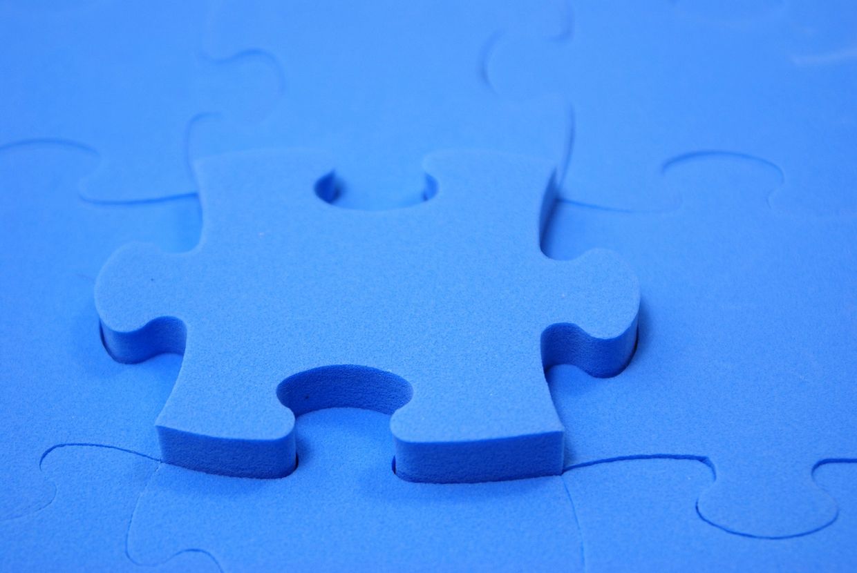 Close-up of a blue foam puzzle piece on a matching board.