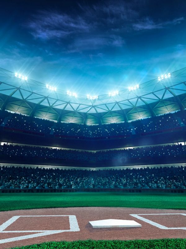 A brightly lit baseball stadium at night filled with spectators.