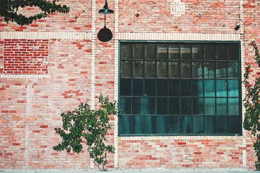 Red brick wall with a large industrial window