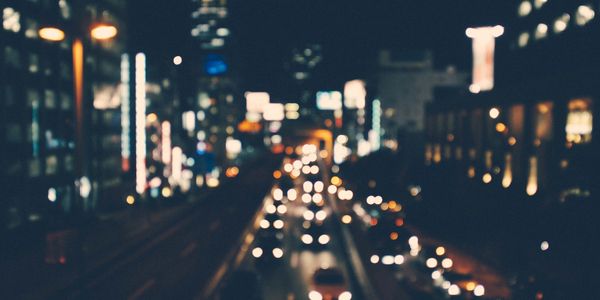 A busy dual carriageway full of cars passing through a city at night