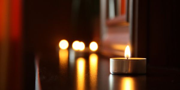 Small candle with single flame on a table