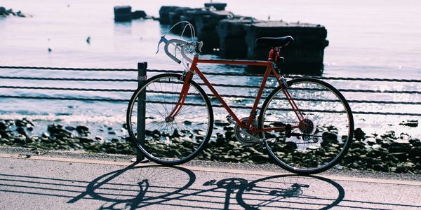 A red bicycle locked near the waterfront.