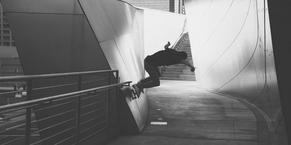 Skateboarder riding his board on a slanted wall.