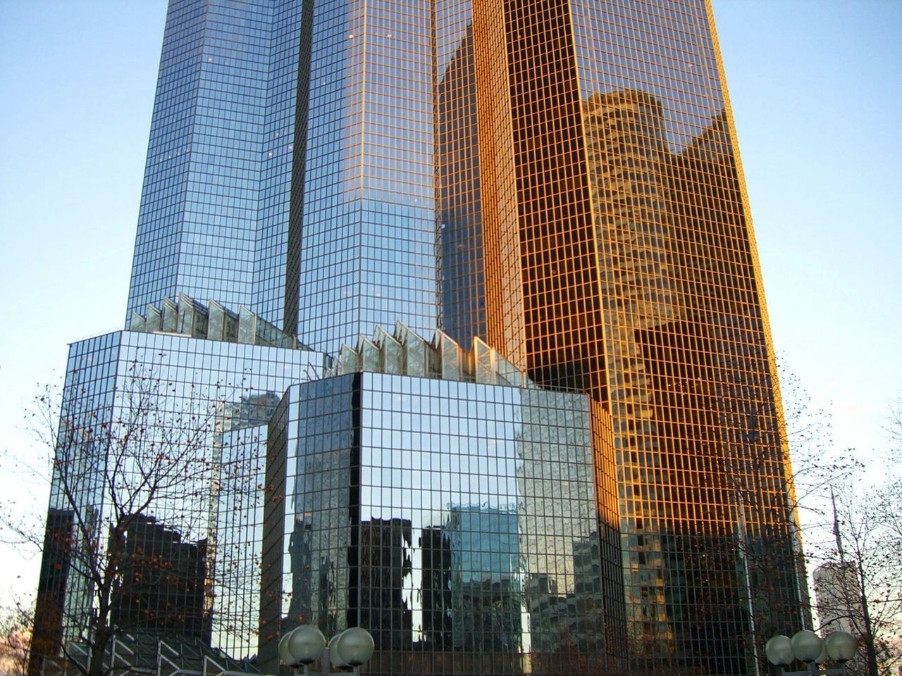 Two large corporate buildings reflect a mirror image of the outside on their mirrored exterior glass.