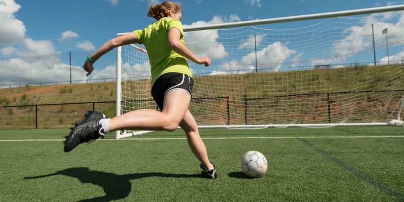 A woman kicking the football into the goal post: we have used this image as symbol for setting goal