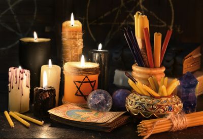 Ritualistic lit candles with smudge sticks, tarot cards, incense, witchcraft, spells, crystal ball