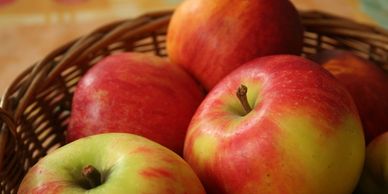 A basket filled with fresh red and yellow apples.