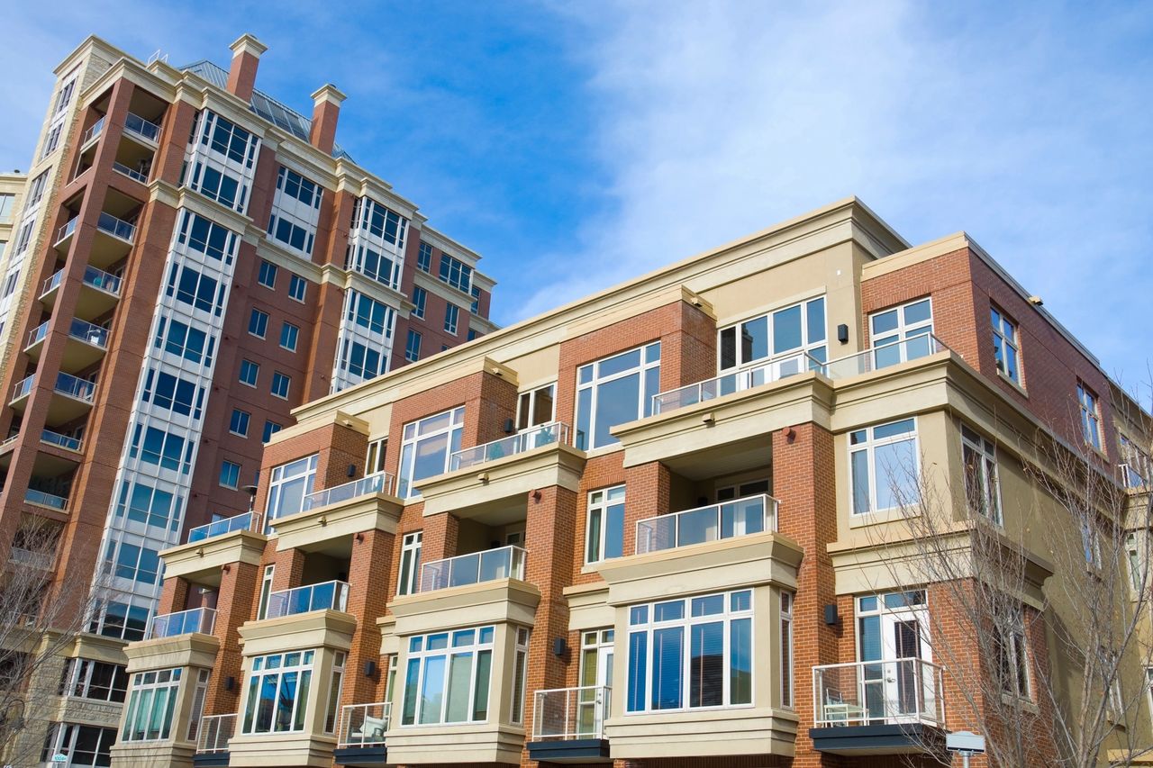 A red brick with tan accented apartment complex.