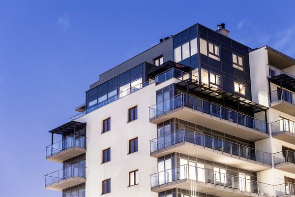 A multistory building using glass to enclose the balconies.