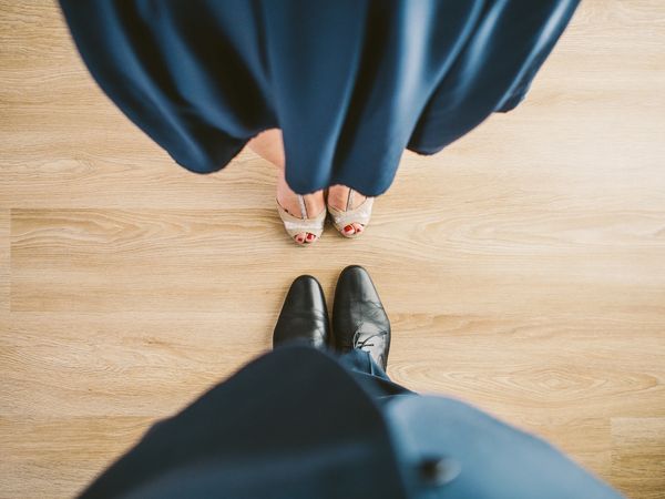 Top view of a couple standing close, showing their feet and attire.