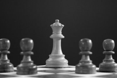White queen chess piece surrounded by pawns.