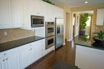 Modern kitchen with white cabinets and stainless steel appliances.