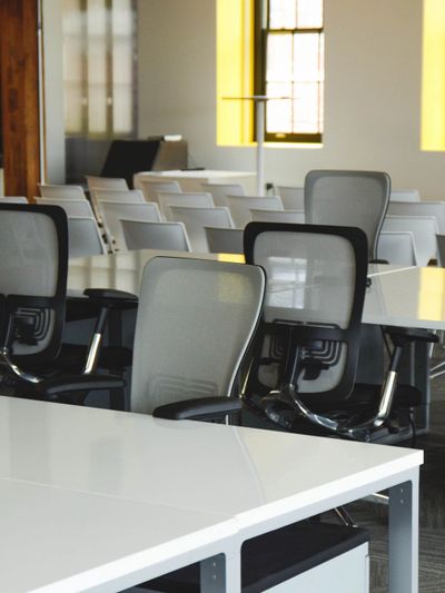 Modern office space with ergonomic chairs and white desks.