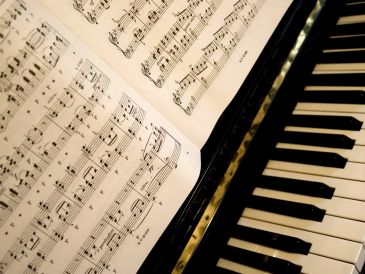 Close-up of piano keys with sheet music.