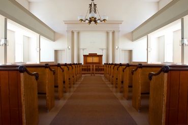 Interior view of a church with wooden pews and a pulpit.