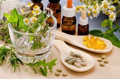 A photo of supplements, herbs, liquid herbal blends, chamomile flowers, rosemary.