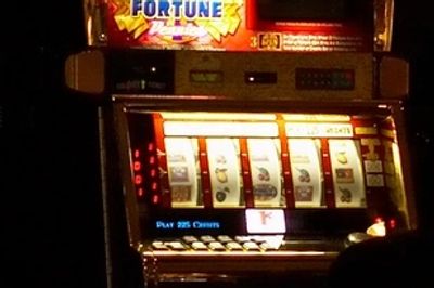 A classic slot machine with spinning reels and illuminated display.
