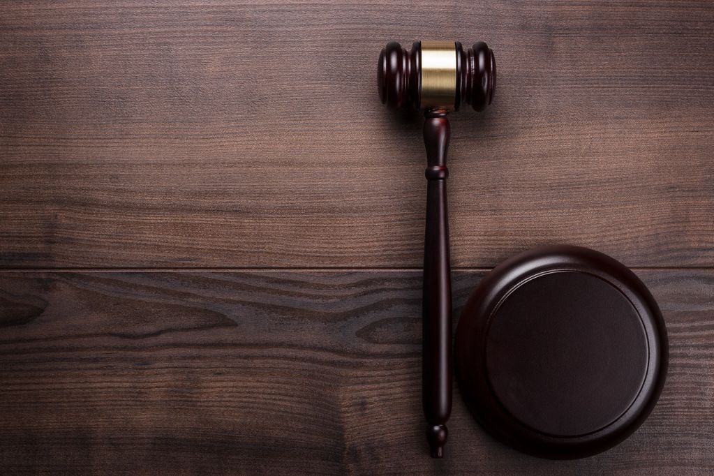 Un marteau de juge en bois sur une table en bois.