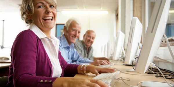 Three elderly people on computers